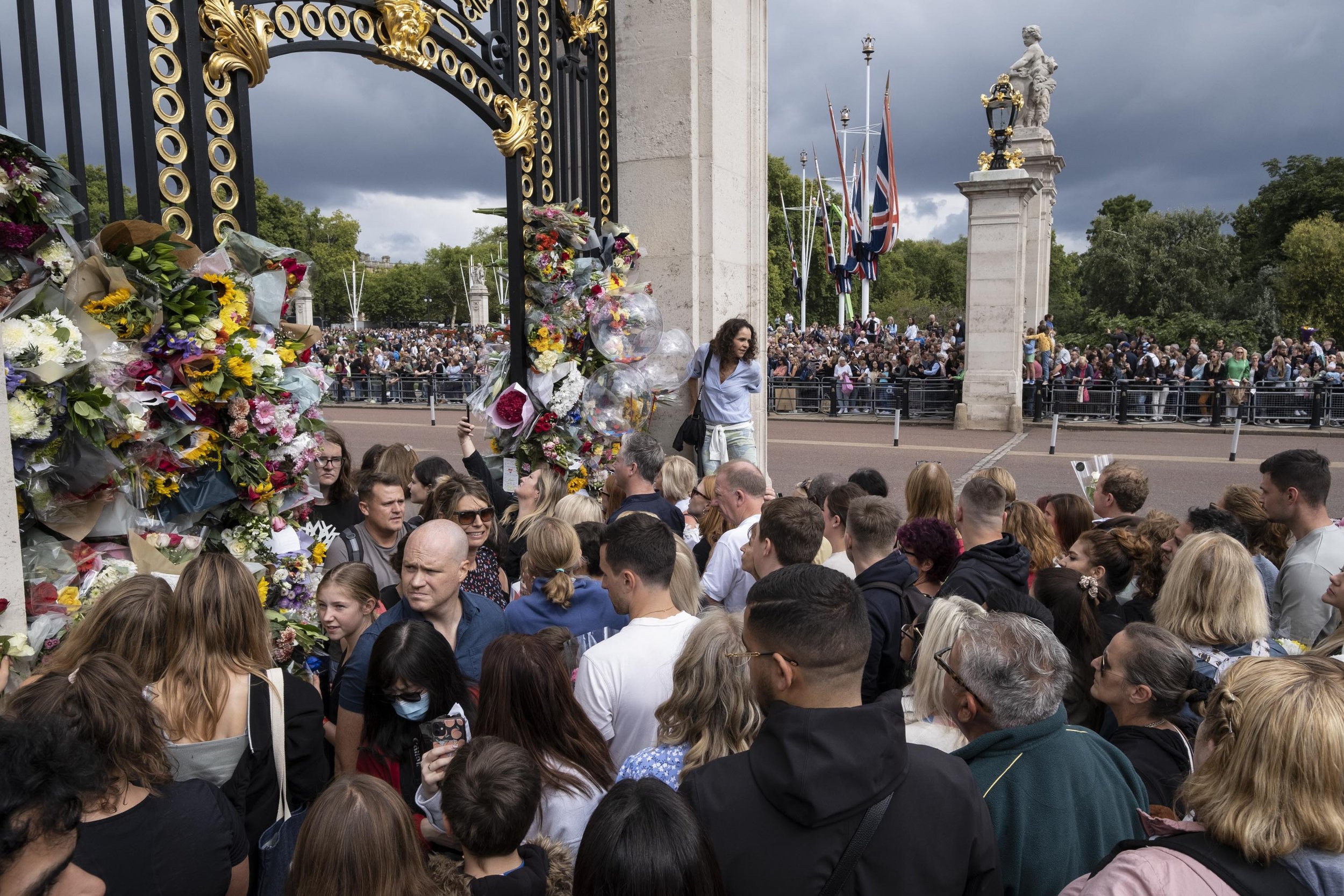  Crowds of people begin to leave flowers in the gates surrounding Buckingham Palace. 