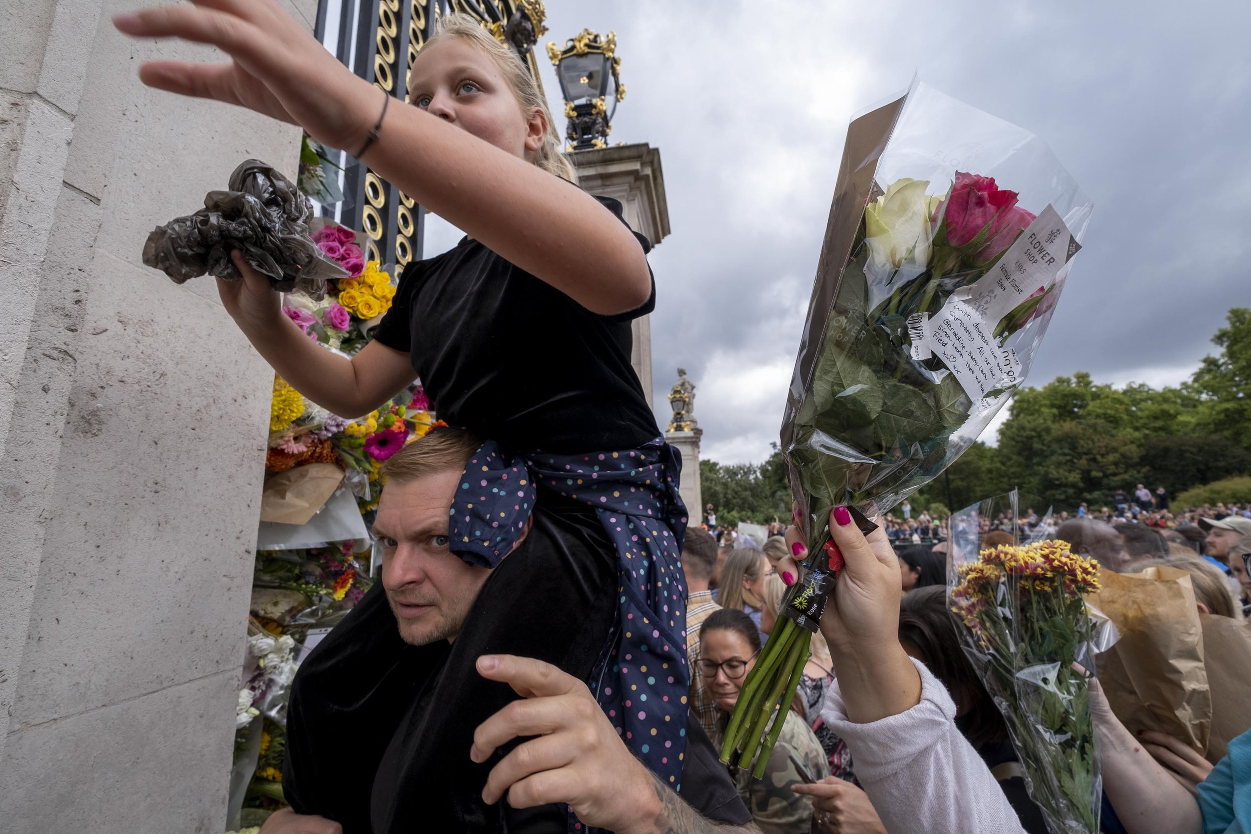  Crowds of people begin to leave flowers in the gates surrounding Buckingham Palace. 