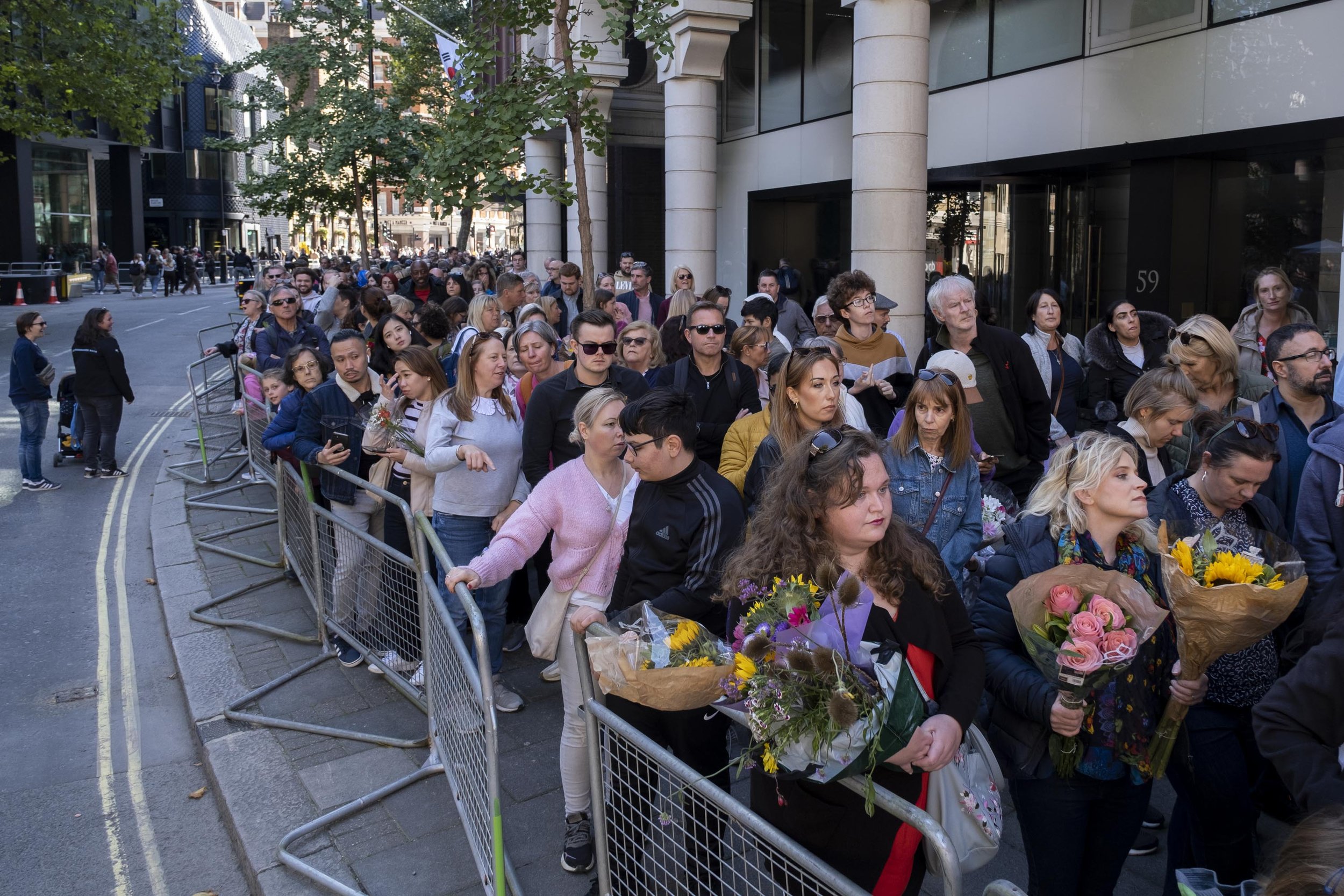  Thousands of people queue up to pass Buckingham Palace and lay flowers at Green Park. 