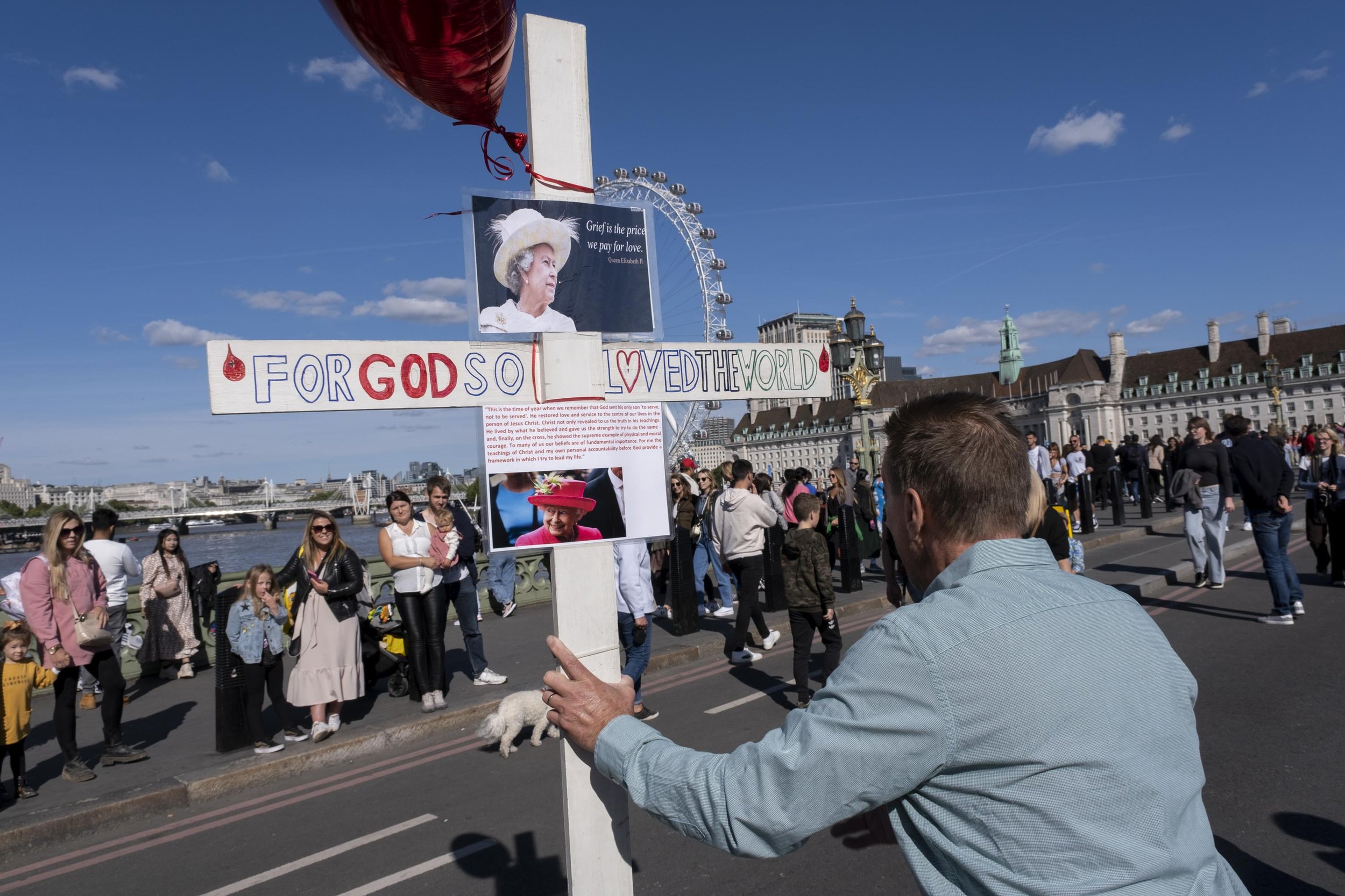  Christian preacher speaks of the faith of the Queen at passers by on Westminster Bridge. 