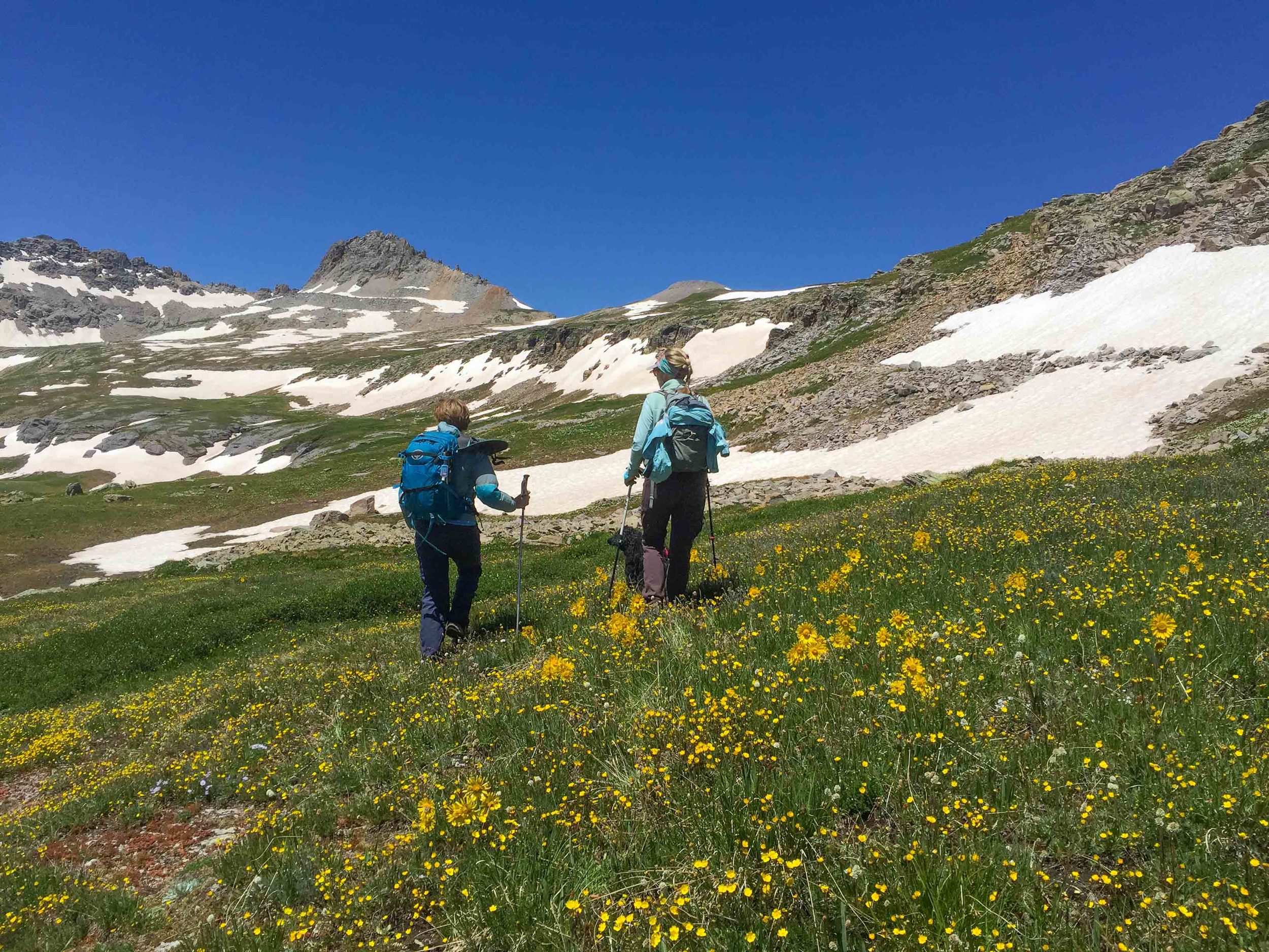 Penny and Jane Marie hike straight ahead towards Columbine Pass in the distance. 