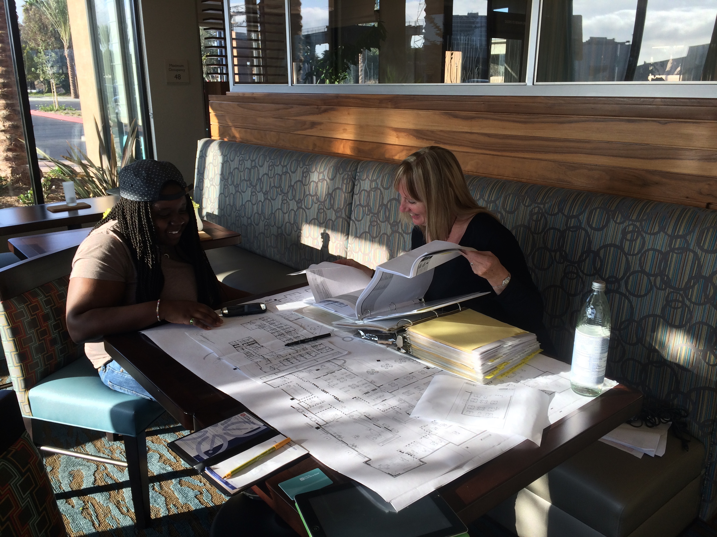 Jane and Shernise reviewing furniture finishes, artwork, and placement.