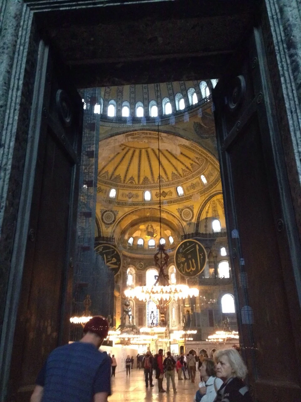 Stepping into the Hagia Sofia. Note the huge gold mosaic of the Virgin Mary holding baby Jesus in the dome at the front and the two huge Islamic "billboards" to either side. Crazy experience.