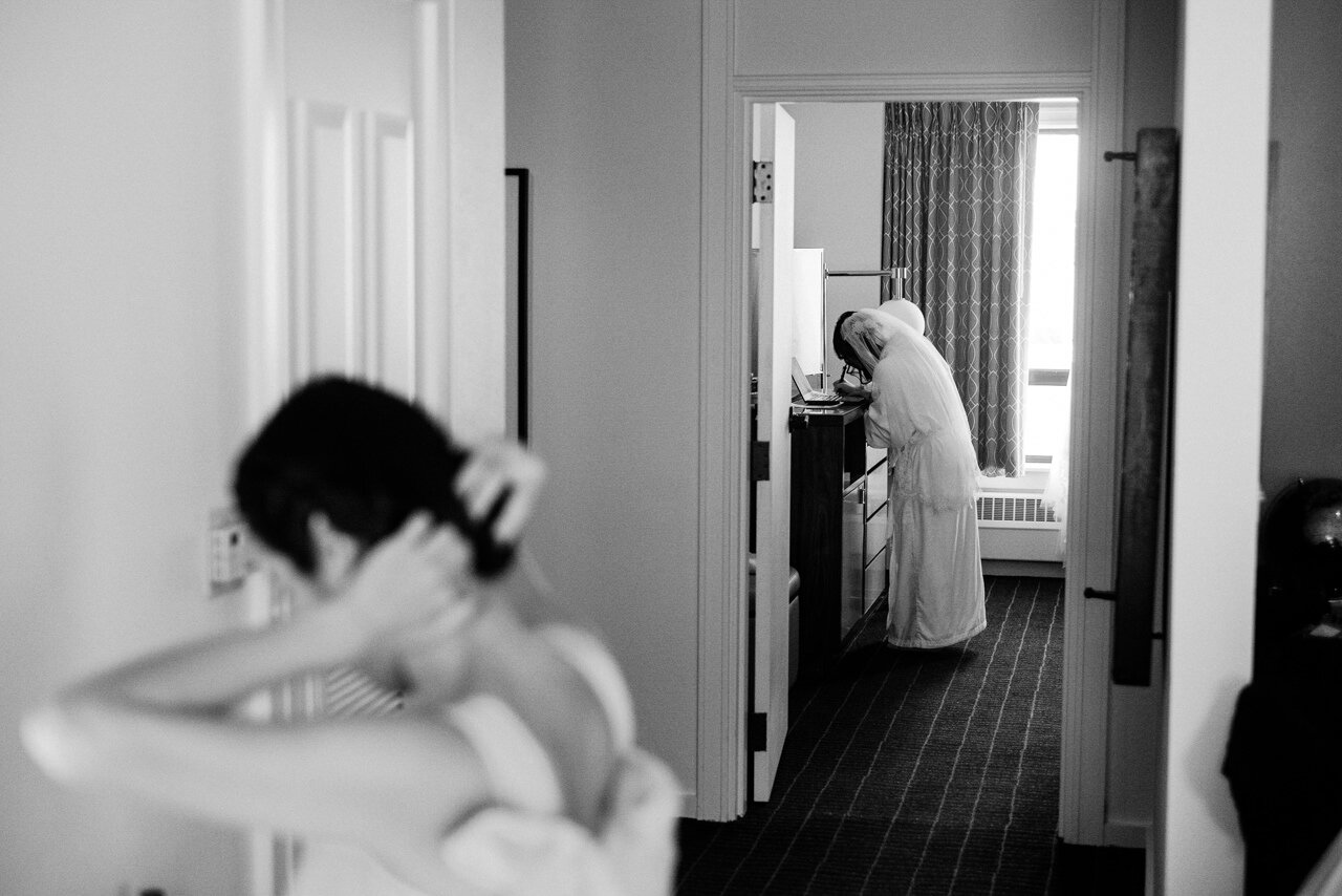  Bride writes vows in hotel room through open doorway 