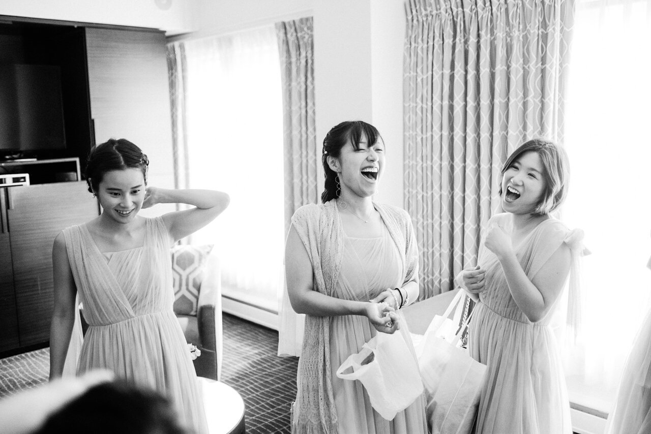  Bridesmaids laughing in hotel room 