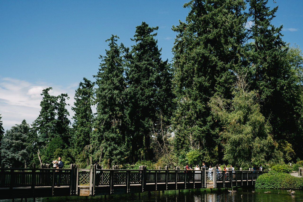  Bridal party walks across wooden bridge over water at crystal springs 