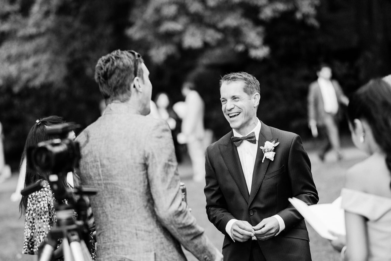  Groom laughs with with wedding guests 