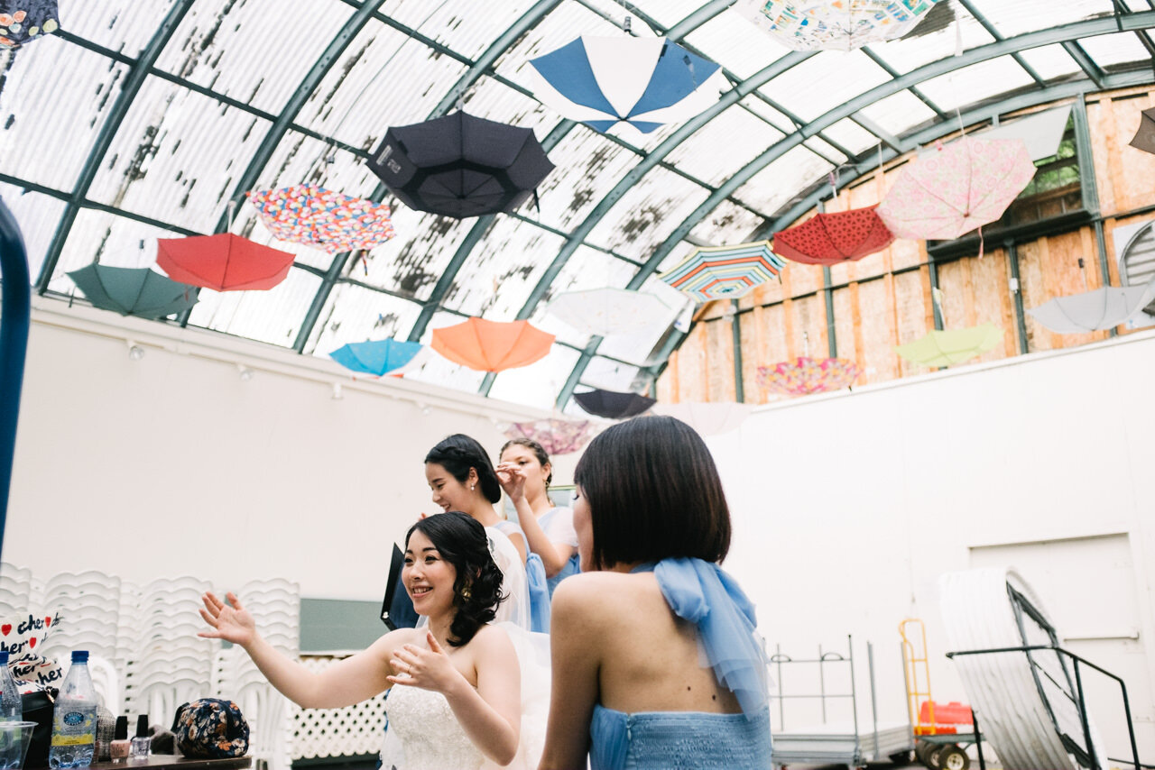  Candid moment of bride and bridesmaids under upside down hanging umbrellas at crystal springs rhododendron garden 