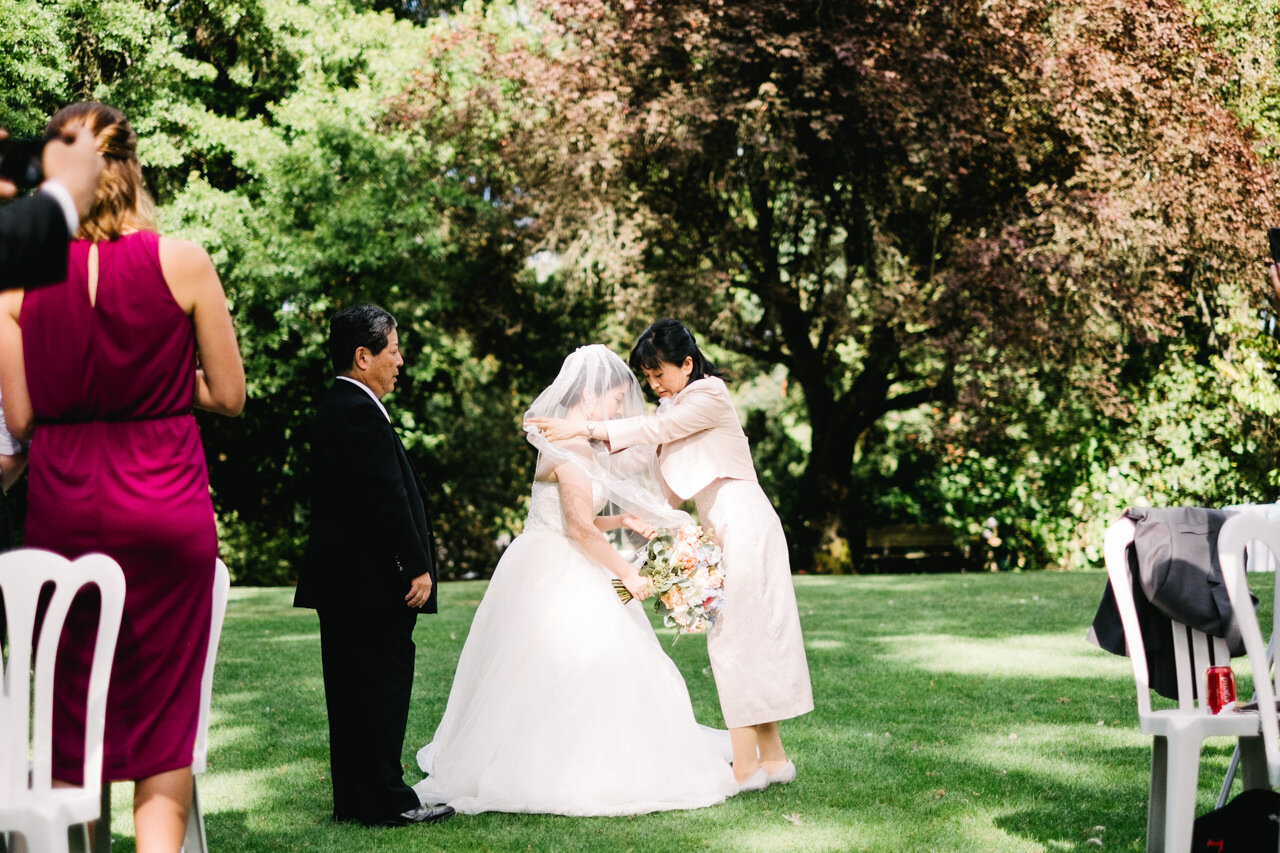  Bride's mother covers bride in veil before entering the wedding at crystal springs garden 