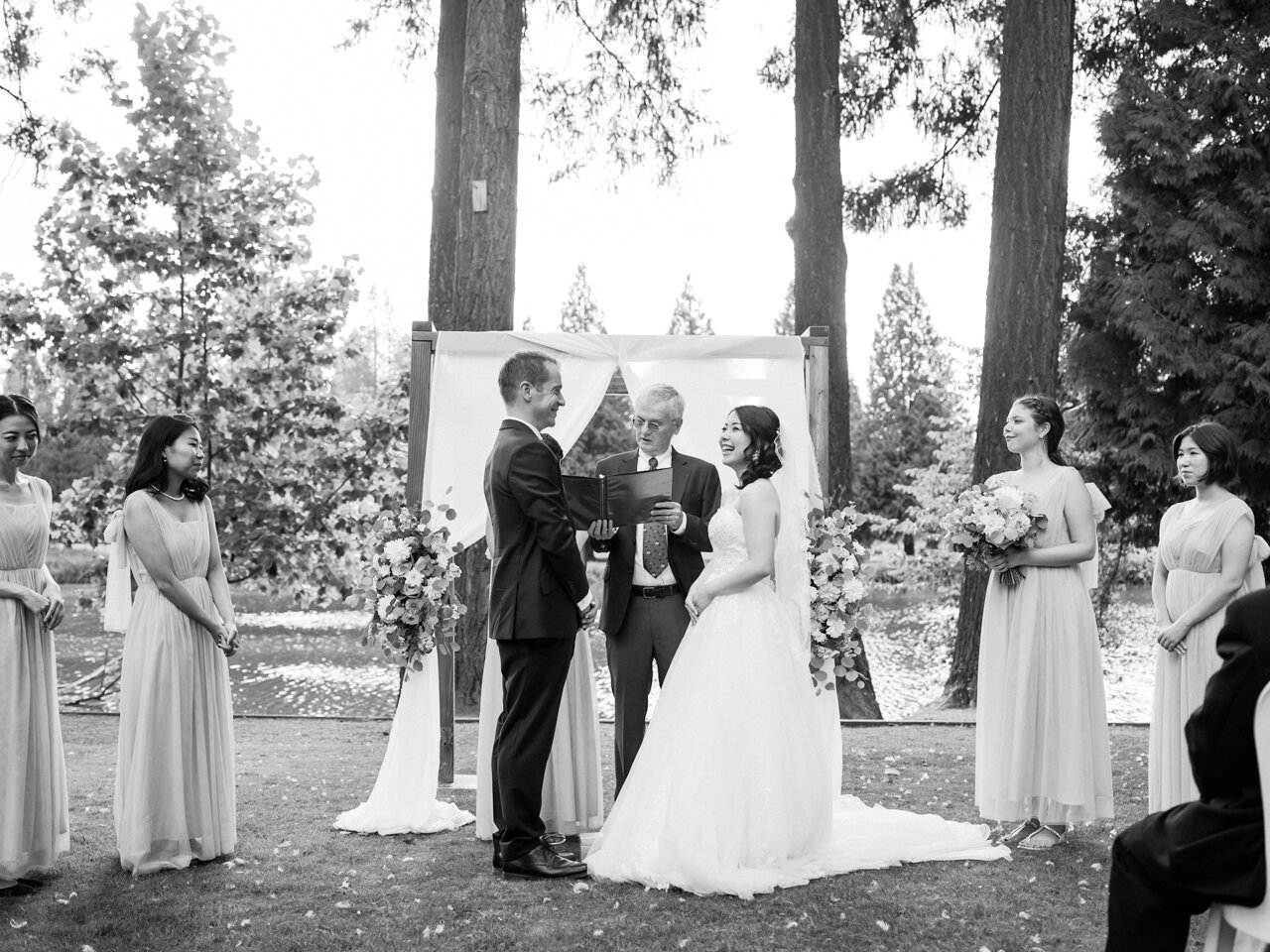  Bride laughs in wedding ceremony in candid black and white moment 