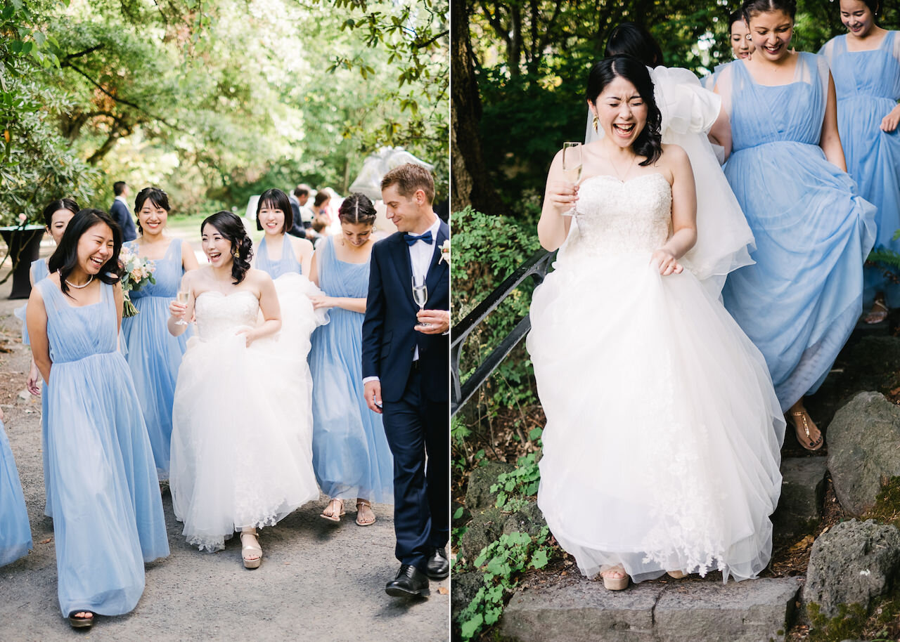  Bride laughing walking down stone steps and holding champagne glass with bridemaids holding dress 