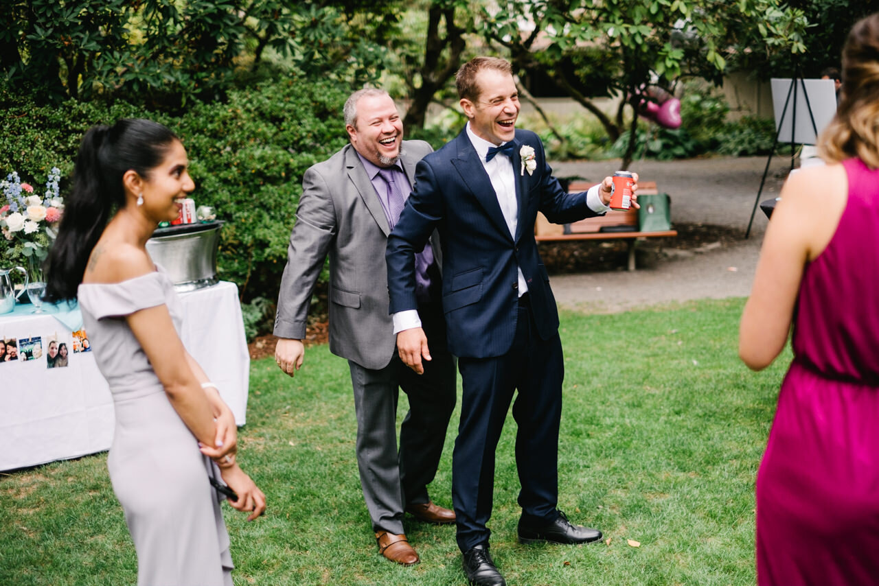  Groom laughs while guest sneaks up on him from behind 