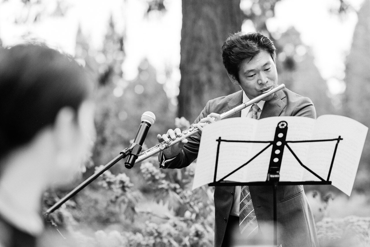  Wedding guest plays flute solo during outdoor Portland Wedding reception 