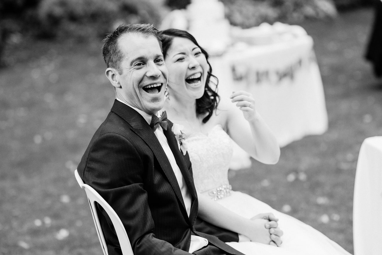  Groom in bow tie laughs at toasts in black and white 