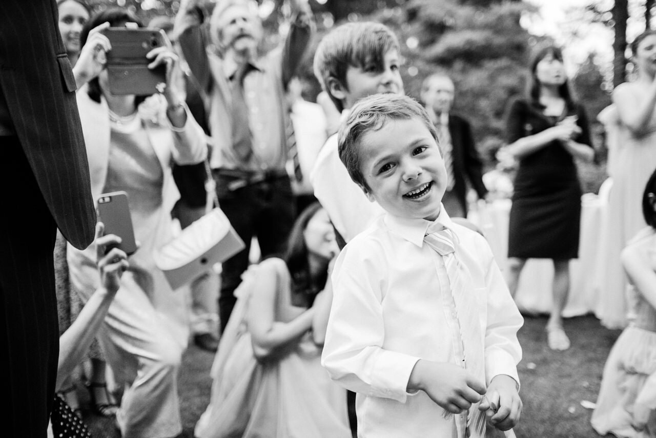  Boy laughs while guests wait for couple 