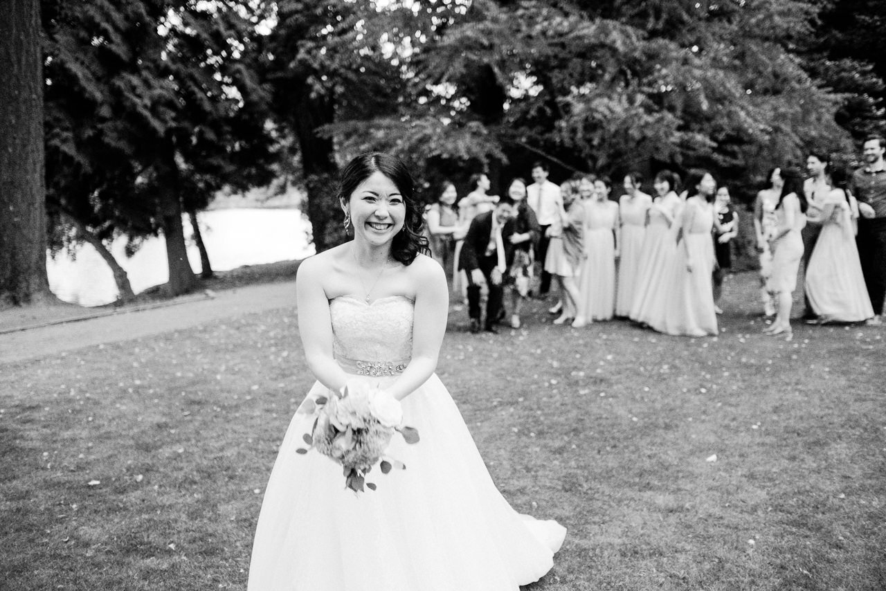  Black and white photo of bride holding bouquet about to toss over her shoulder 