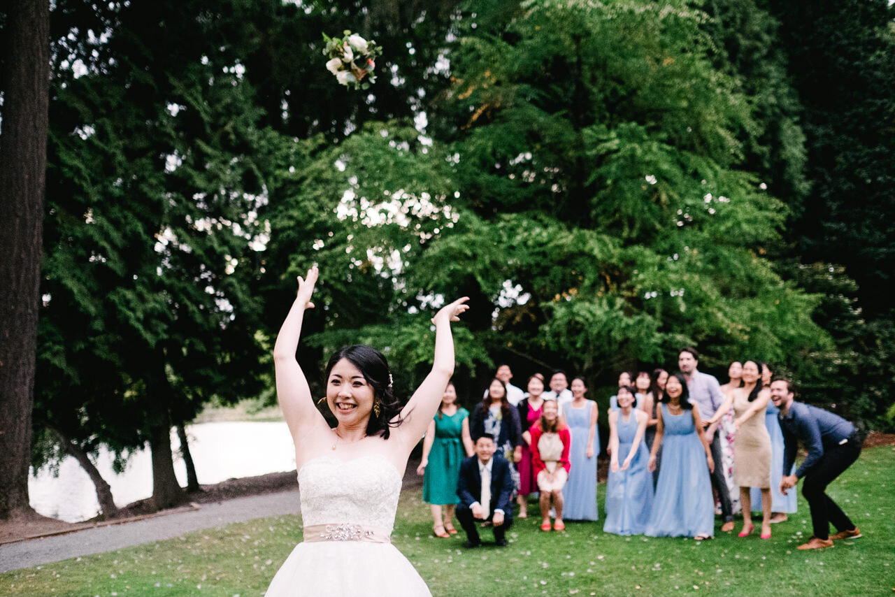  Bride tosses bouquet behind her as bridesmaids and guests wait 