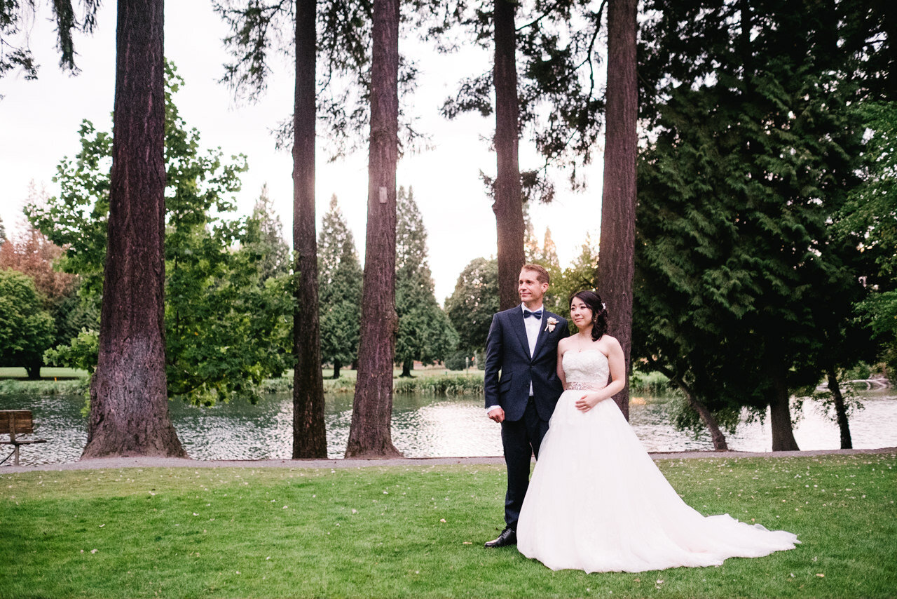  Bride and groom stand in front of tall fir trees at sunset at crystal springs lawn during toasts 