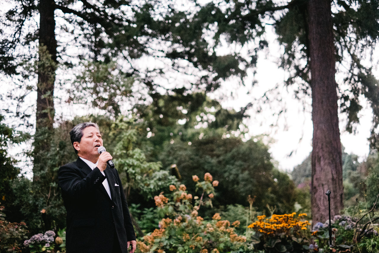  Father of groom sings in outdoor wedding reception 