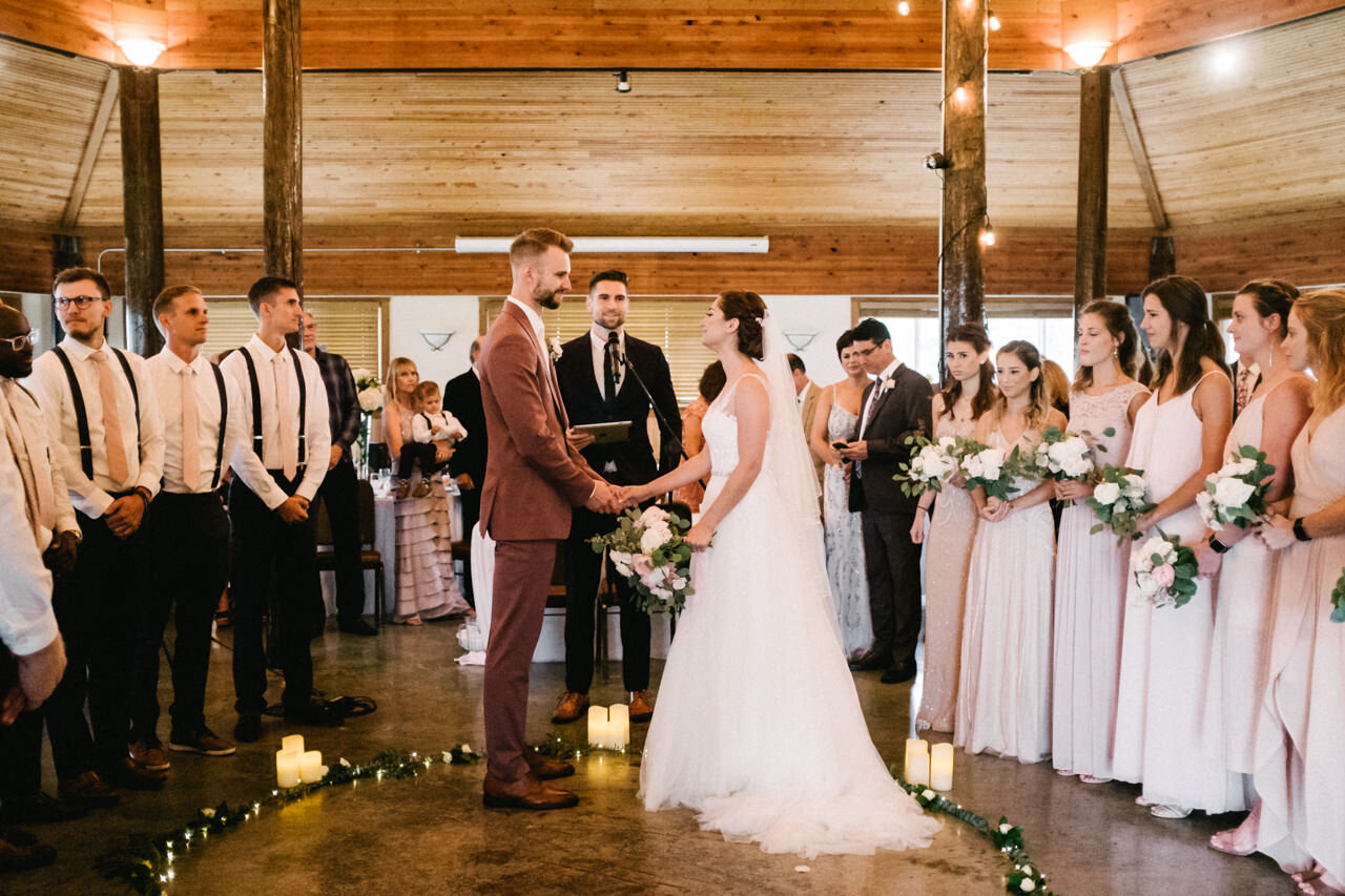  Wedding in cascade locks wood pavilion with led lights and wedding party stand around the bride and groom 