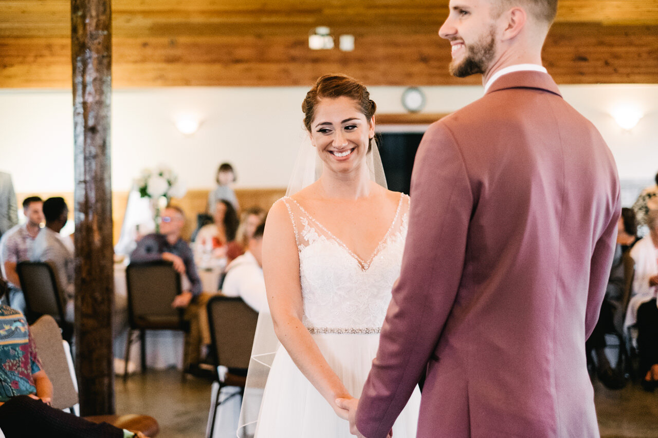  Bride smiles holding hands with groom during wedding at cascade locks 