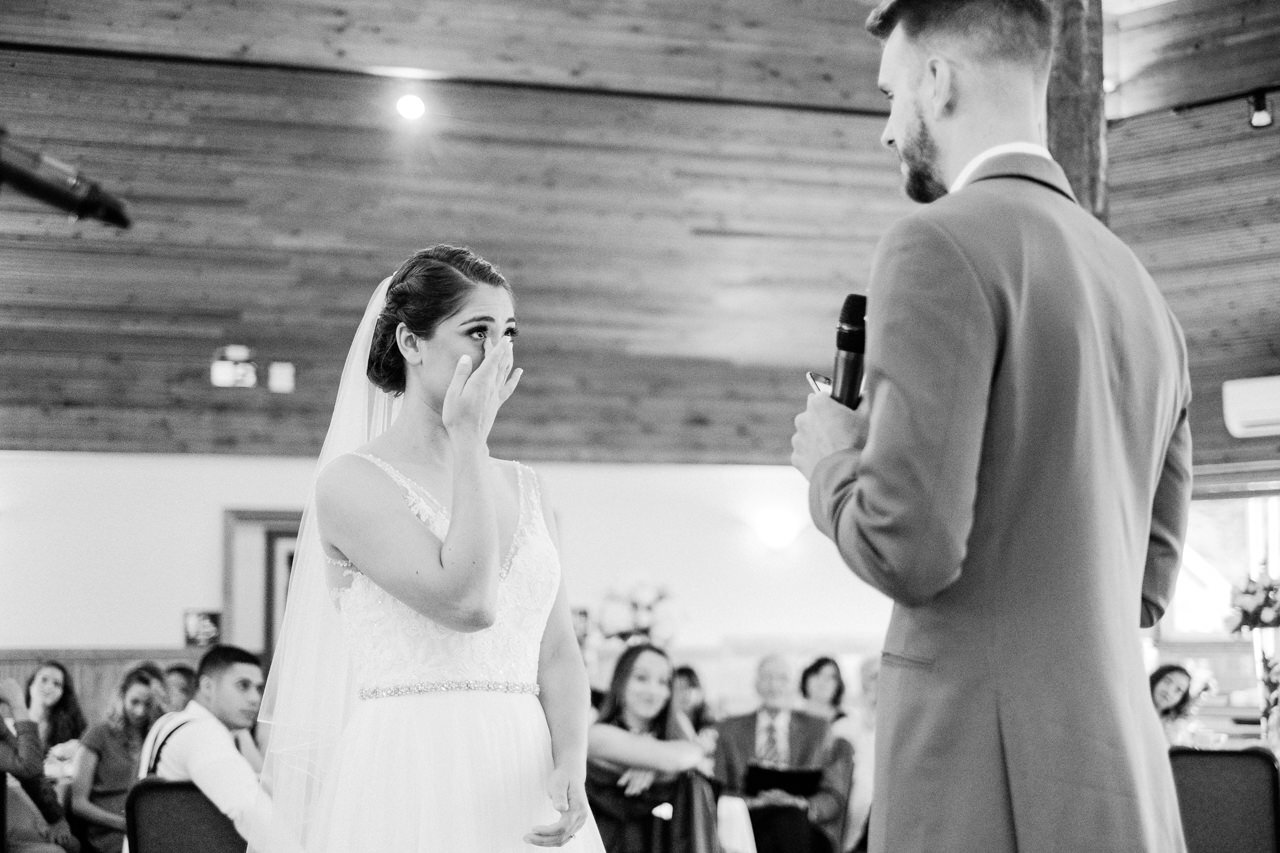  Bride wipes her tears away during wedding vows in black and white photo 