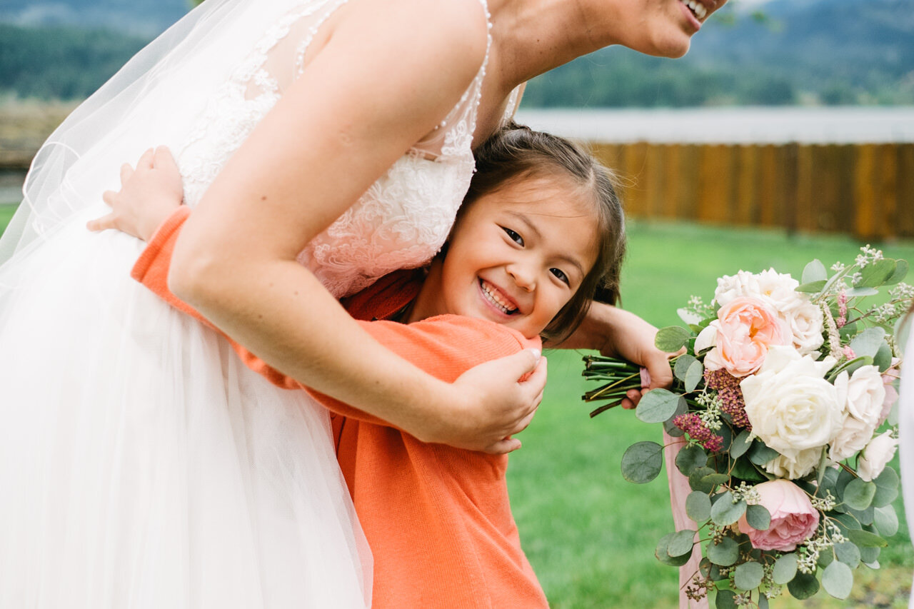  Bride receives big hug from happy girl in orange dress 