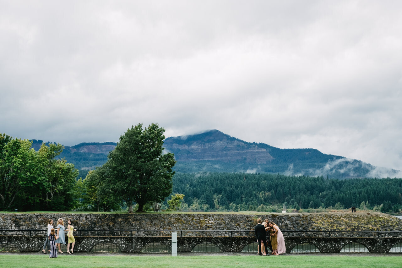  Candid moment of wedding guests taking selfies by Columbia river 