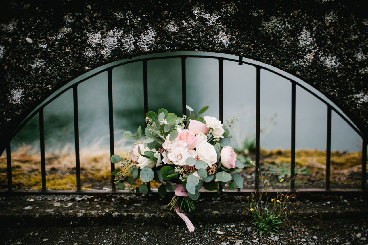  Pink and white bouquet in front of gated arch 