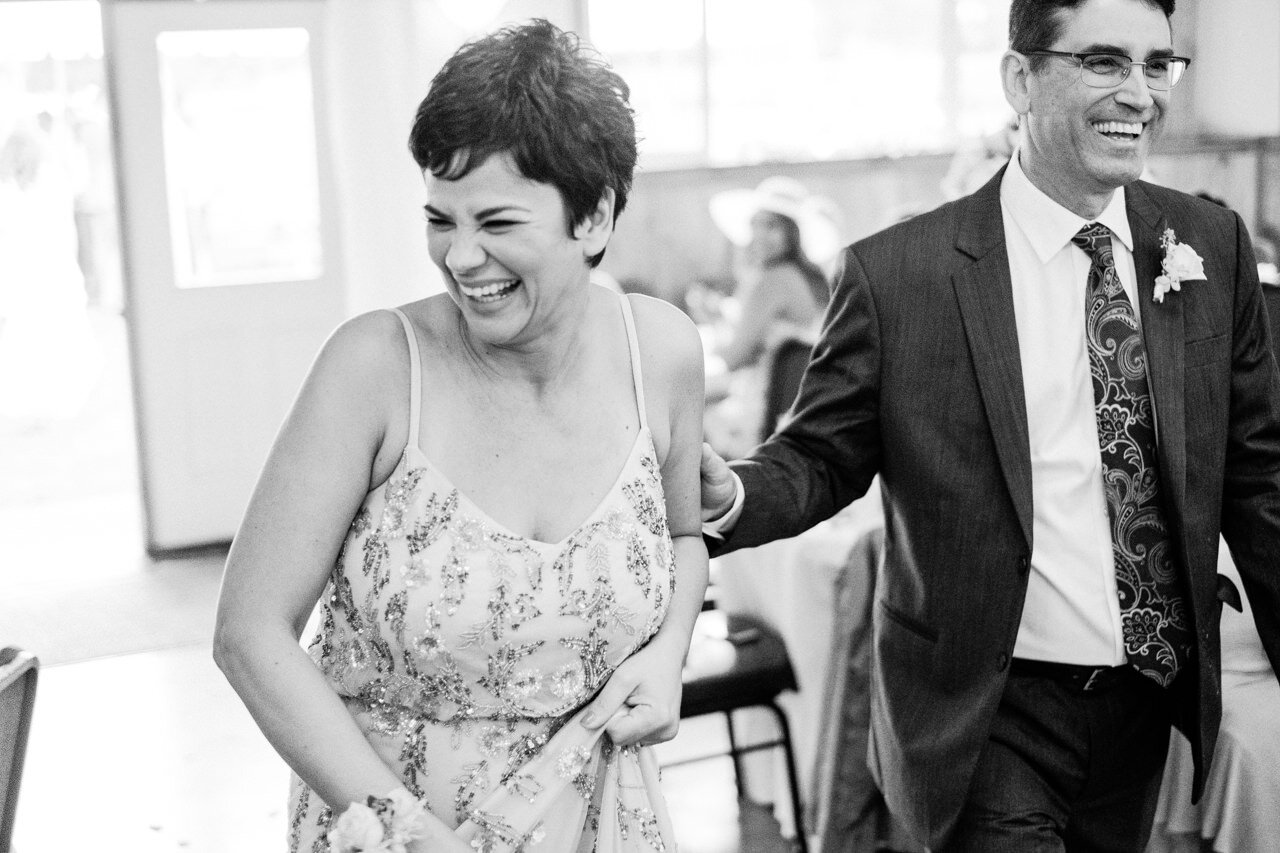  Mother of bride laughs while entering reception 