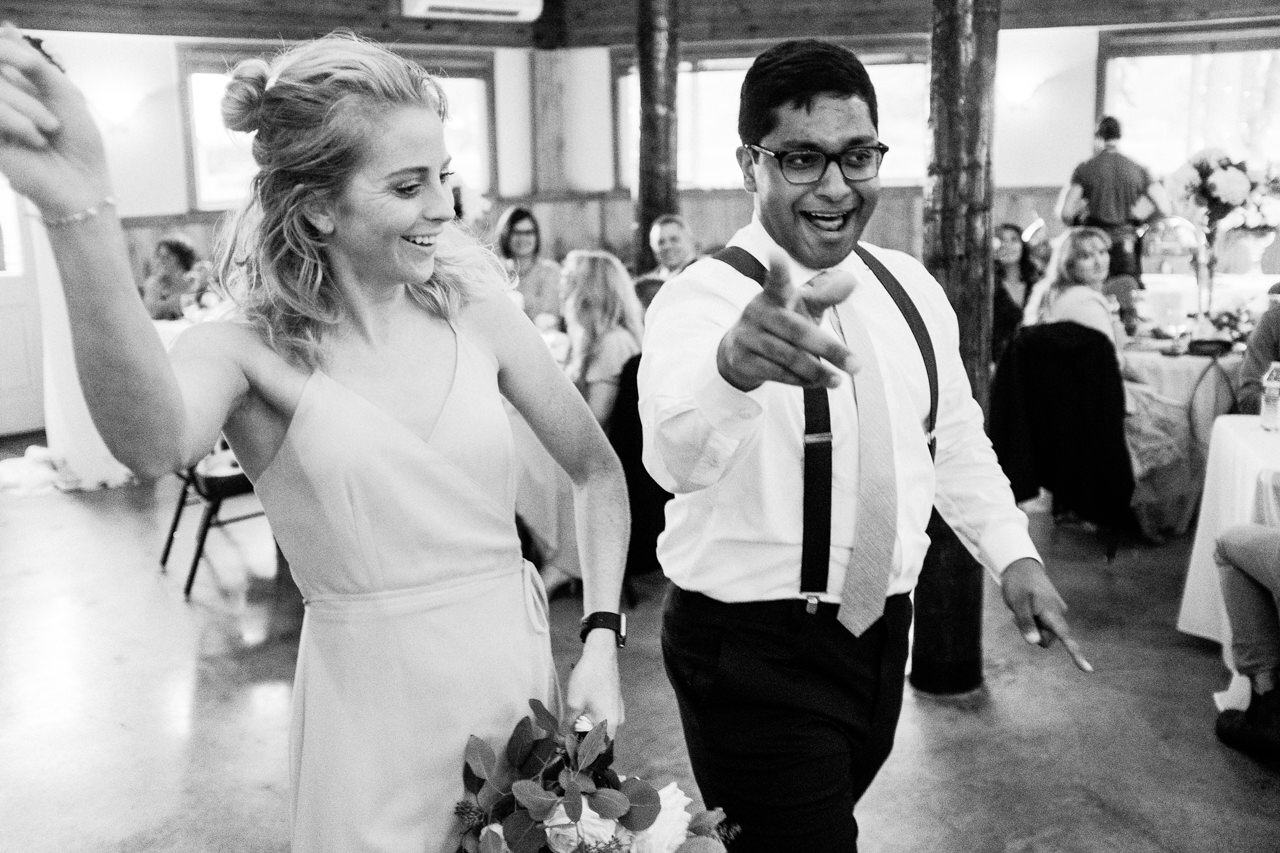  Groomsman goofily dances with bridesmaid while entering reception 