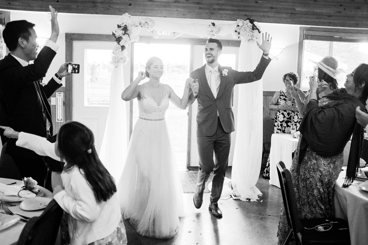  Bride and groom enter reception while dancing and waving 