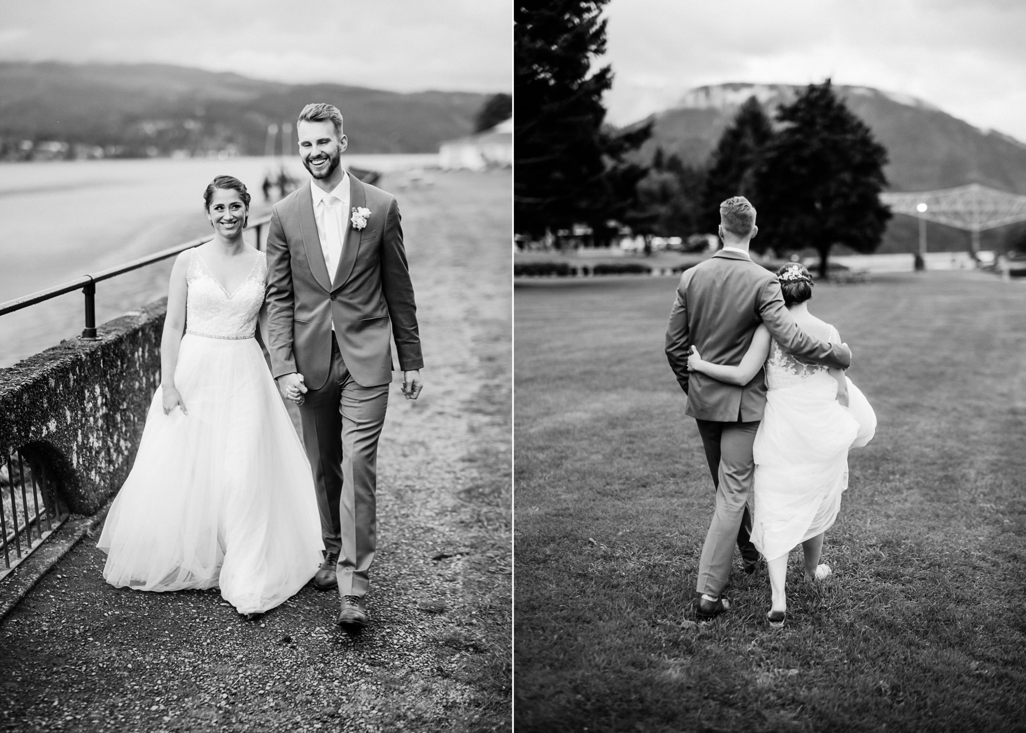  Bride and groom walk together in open field by Columbia river with the bridge of the gods behind them 