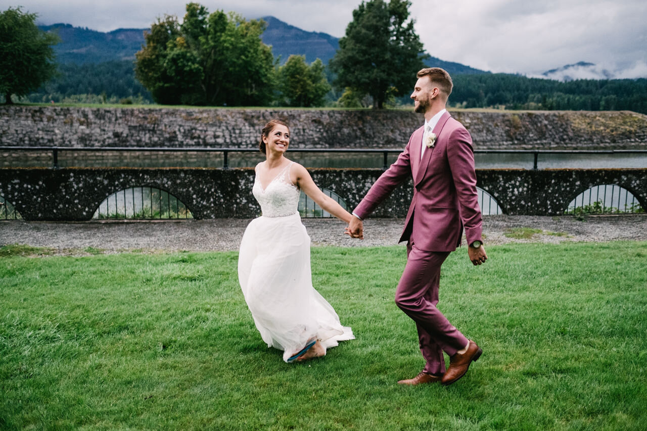  Bride runs while holding hands with groom by cascade locks waterway 