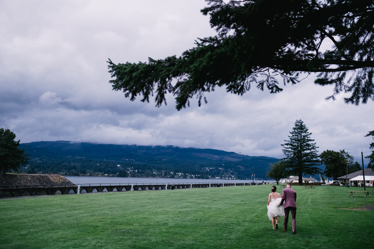  Bride and groom return to wedding reception across field at cascade locks marine park 