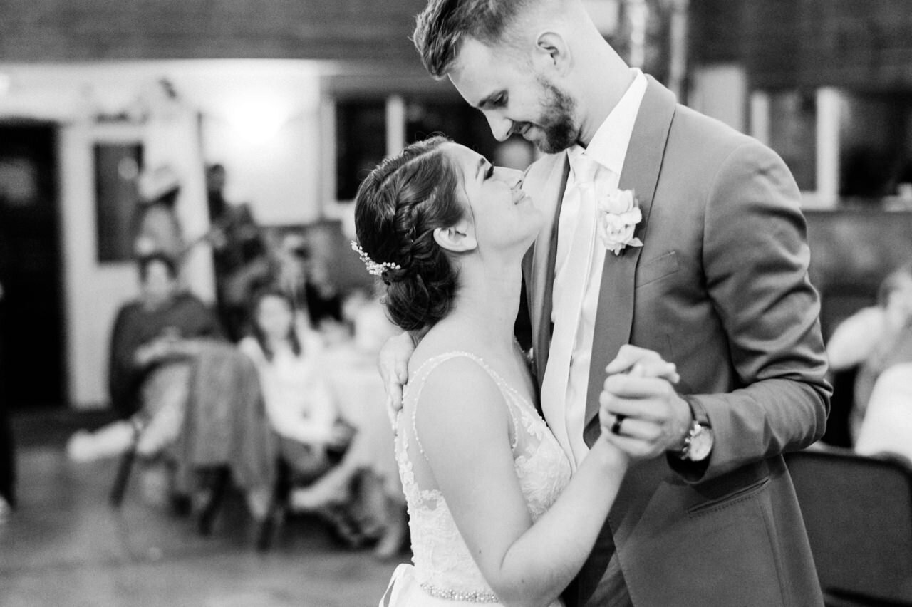  Groom and bride snuggle close during first dance 