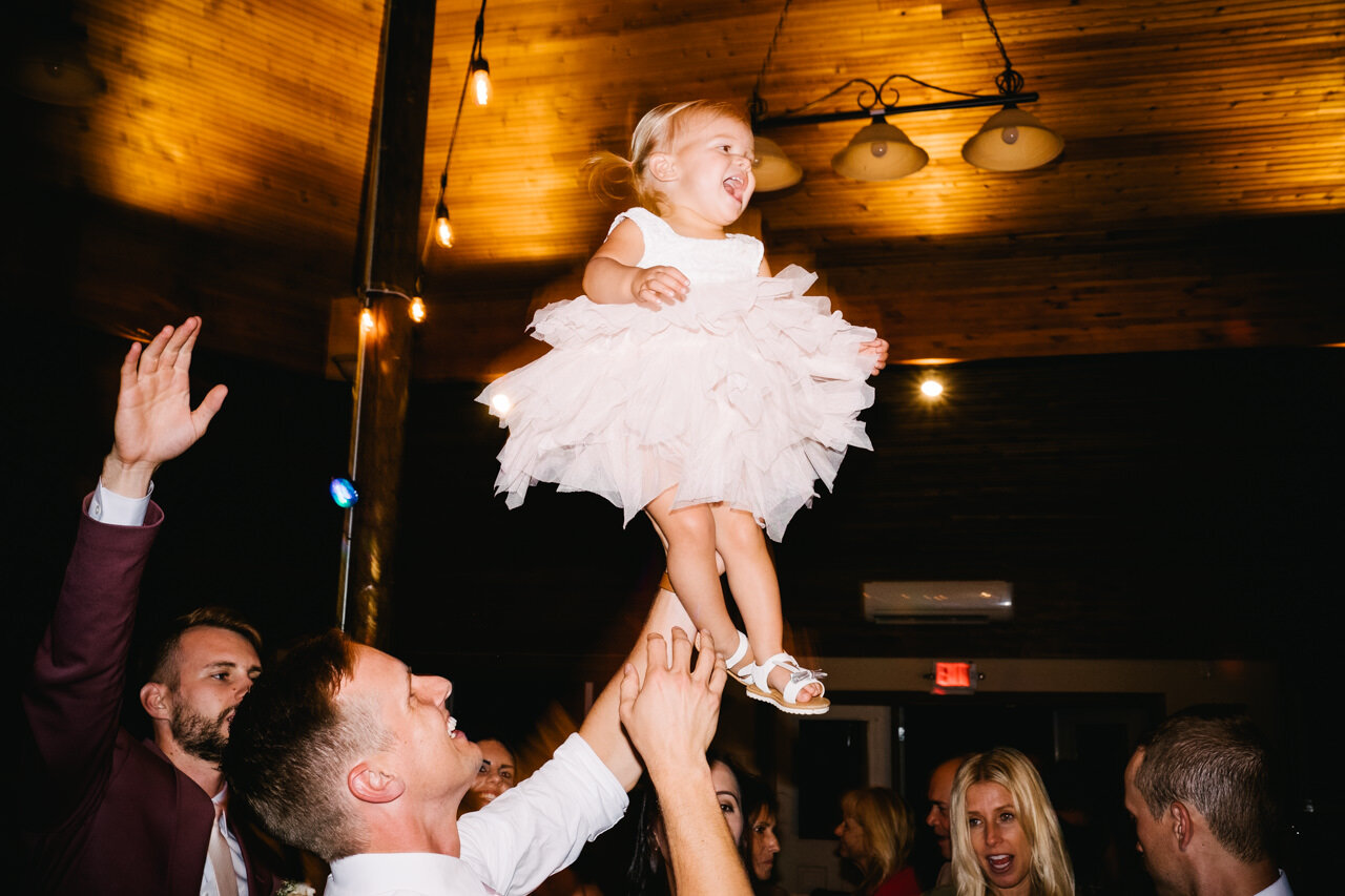  Flower girl tossed in air during wedding dancing 
