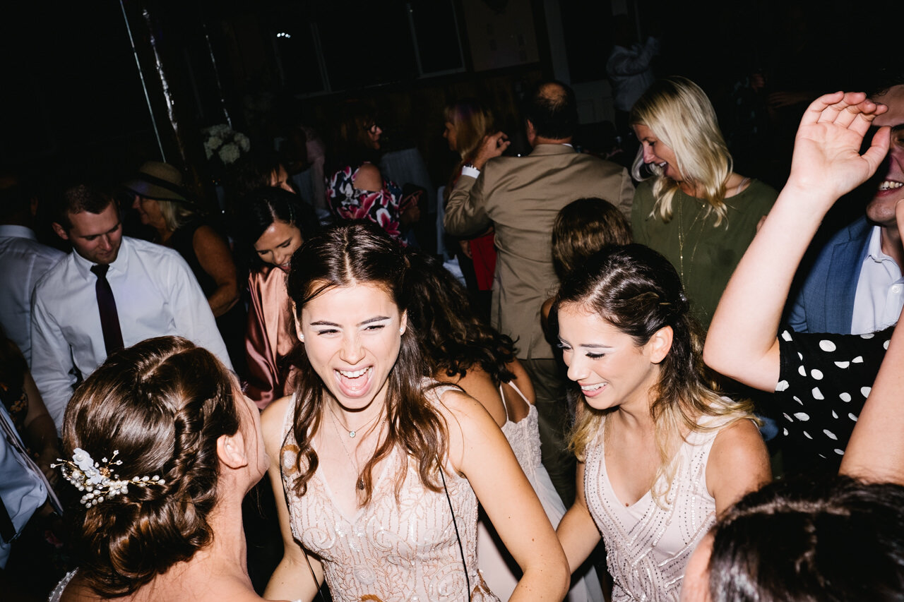  Bridesmaid laughs with bride during party wedding dancing 