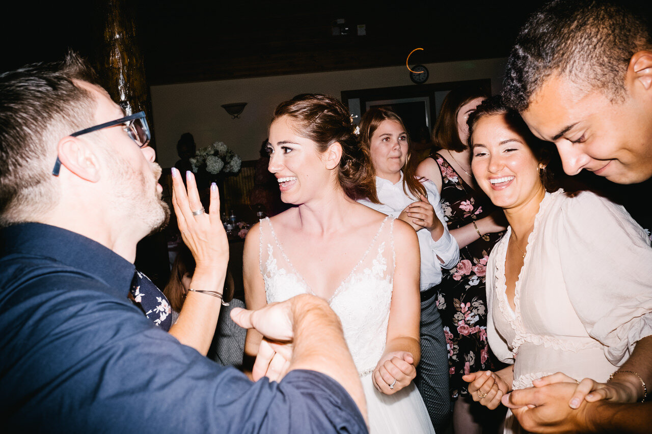  bride smiles with guests on dance floor 