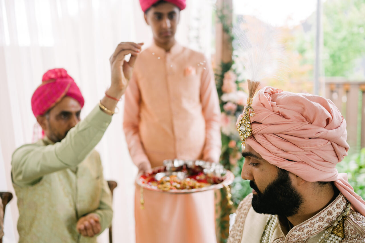  Bride's father tosses rice onto groom's pink turban 