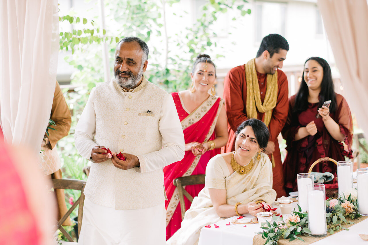  Wedding guests holding rose pedals during saptapadi 