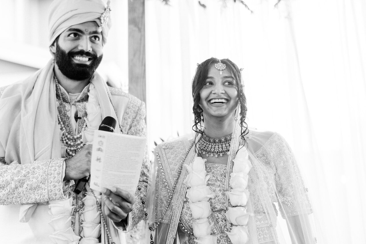  Groom and bride smiling while reading marriage notes 