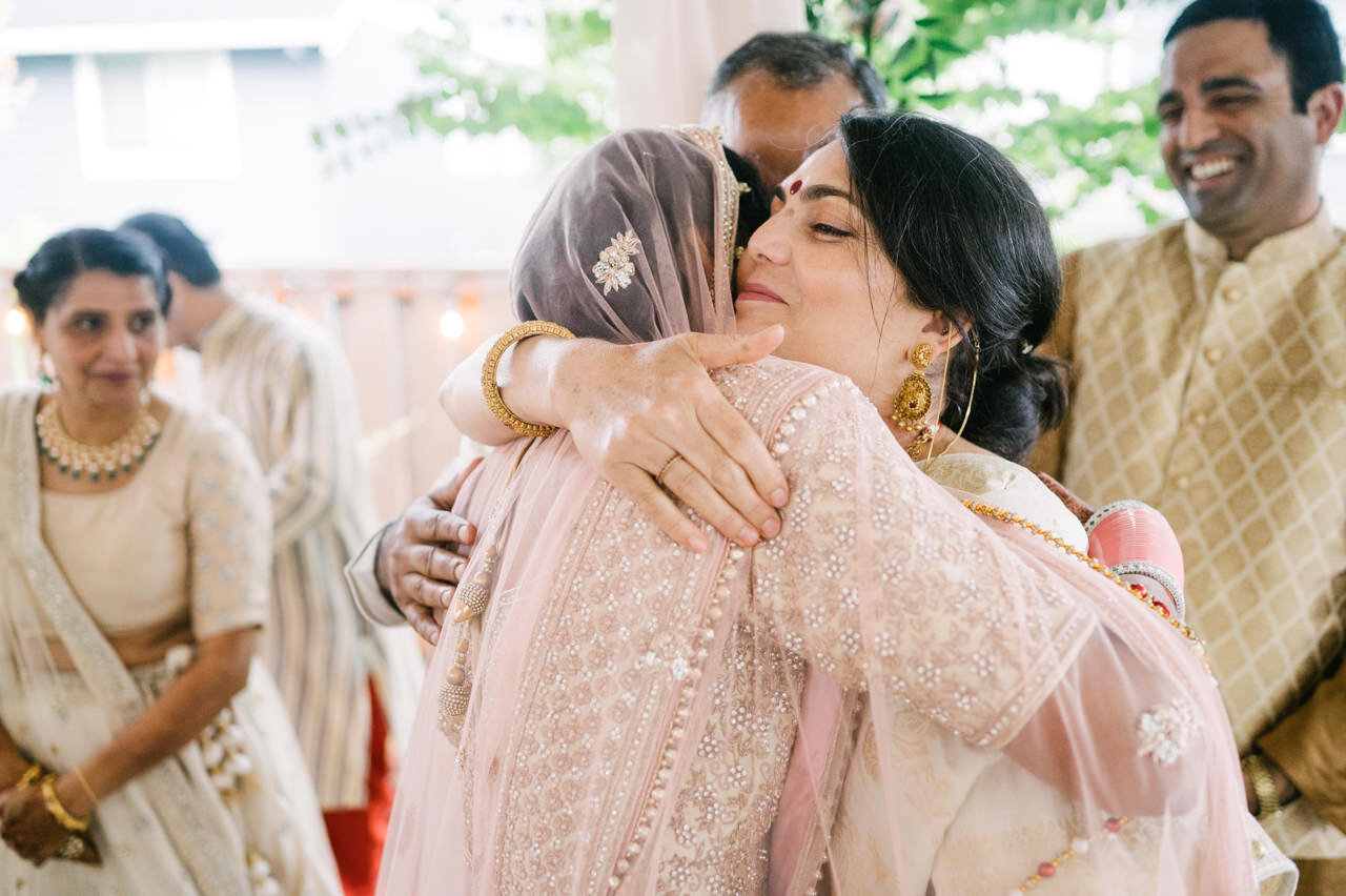  Mother hugs bride after indian wedding ceremony 