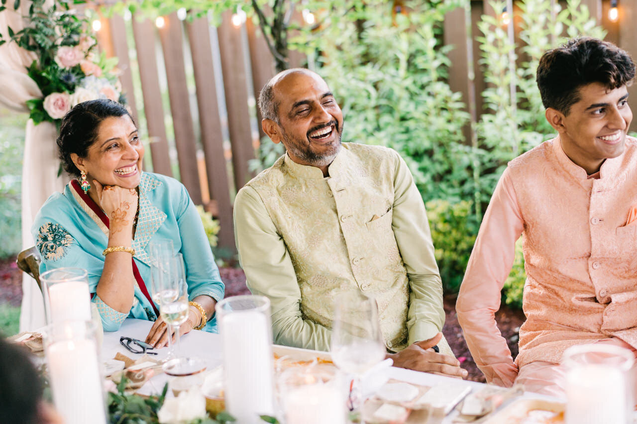  Laughing Indian parents of bride and her brother during family wedding toasts 