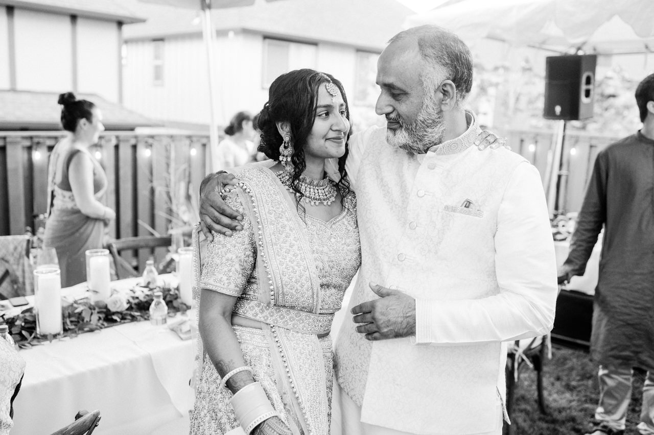  Bride hugs father in law during backyard indian wedding reception 