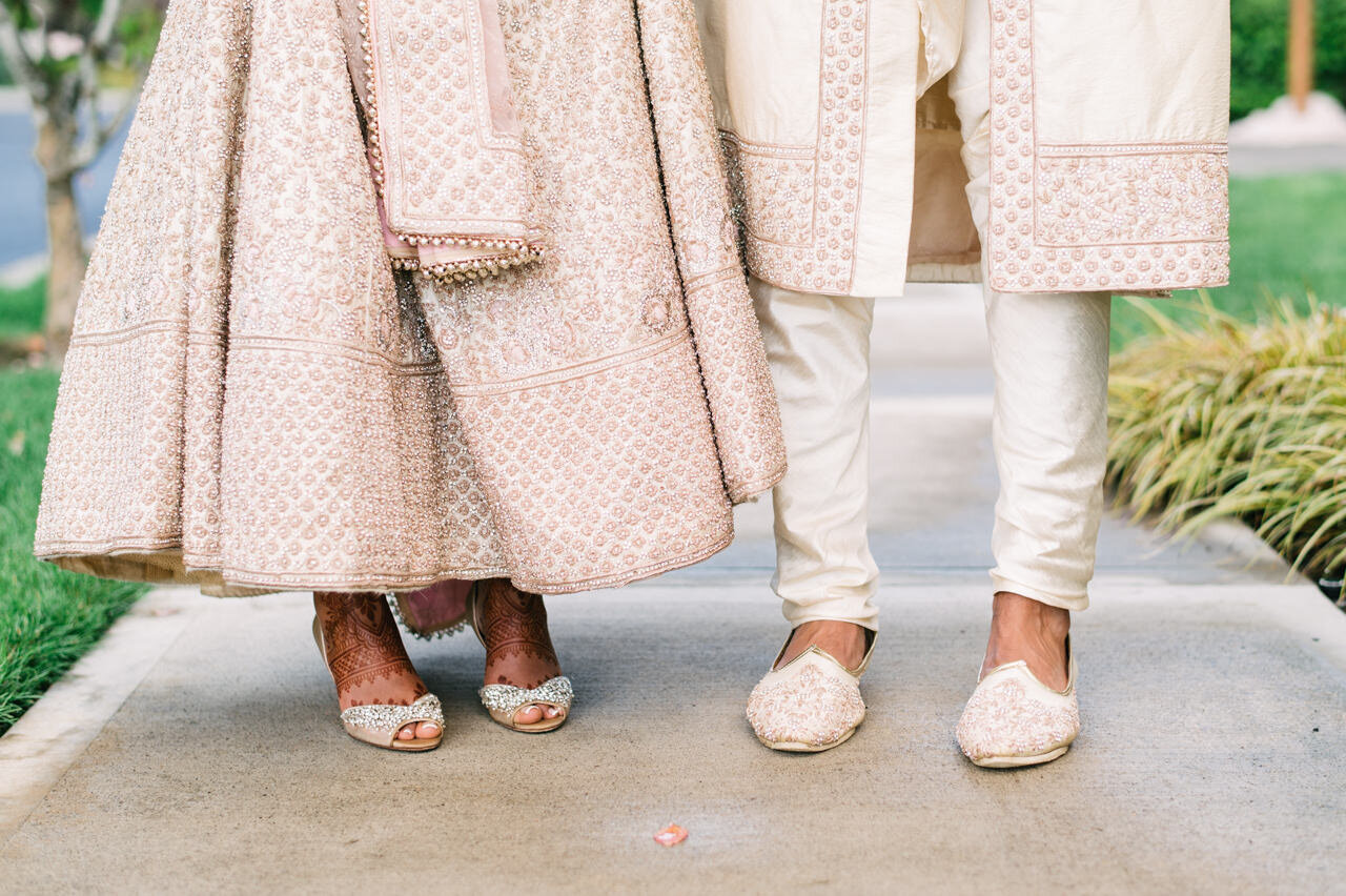  Indian bride and groom show shoes on sidewalk 