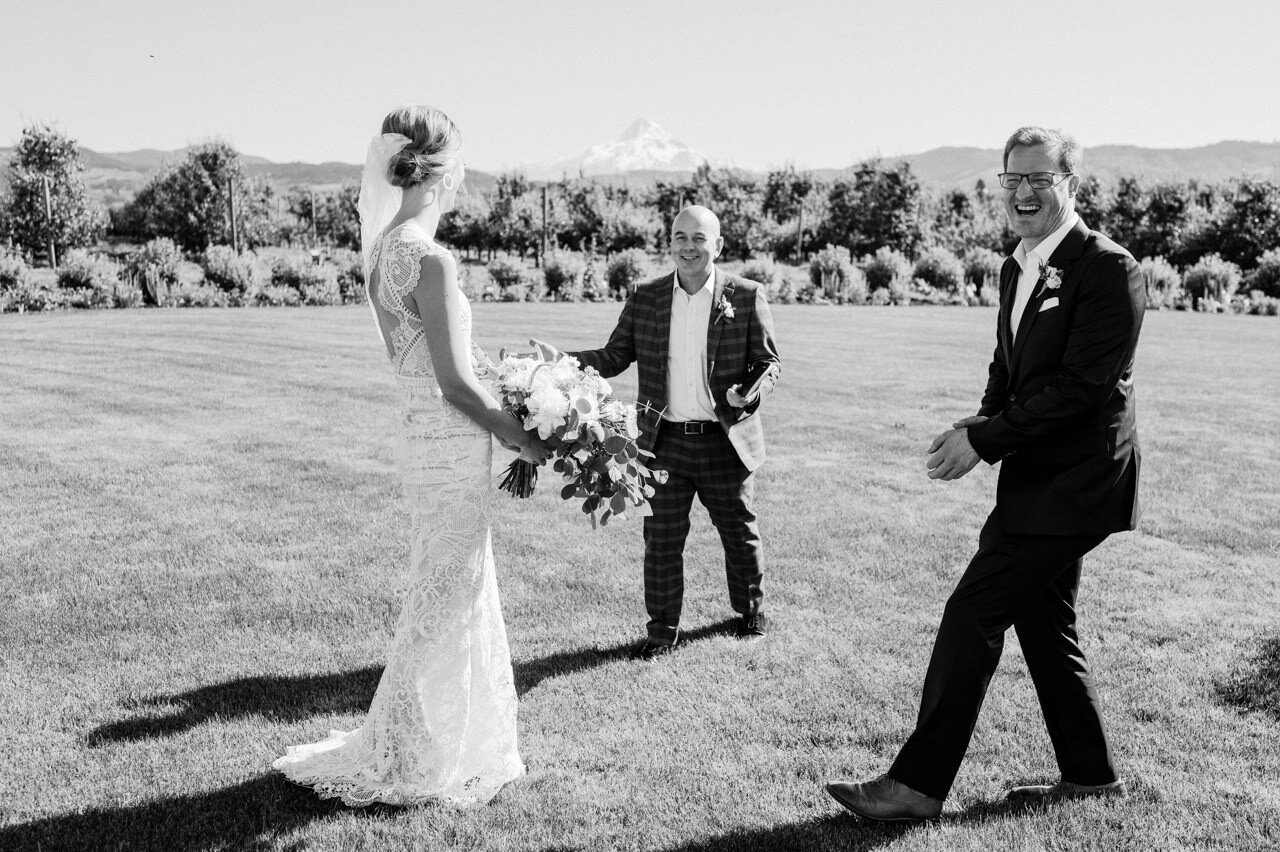  Groom laughs and claps while they set up in front of mt hood 