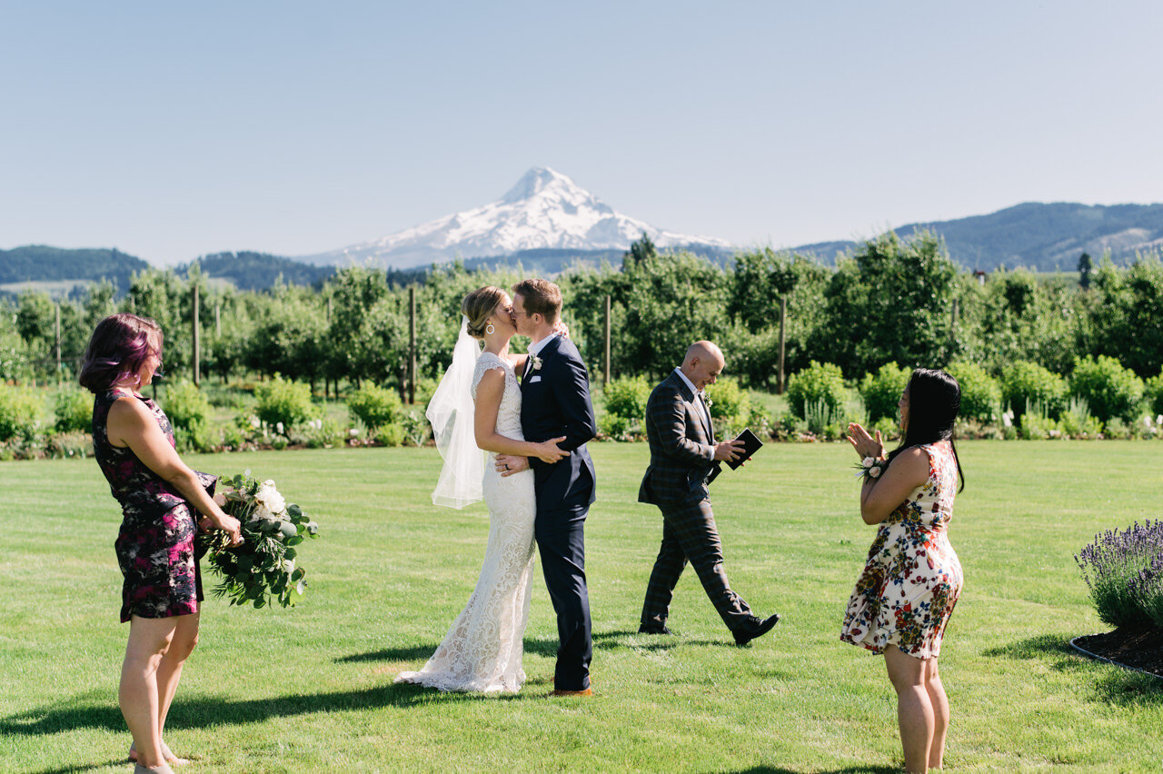 Bride and groom kiss on lawn in front of mt hood during elopement 