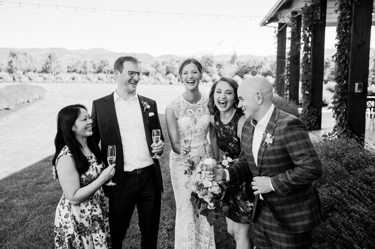  Elopement group cheers champagne while laughing in candid moment 