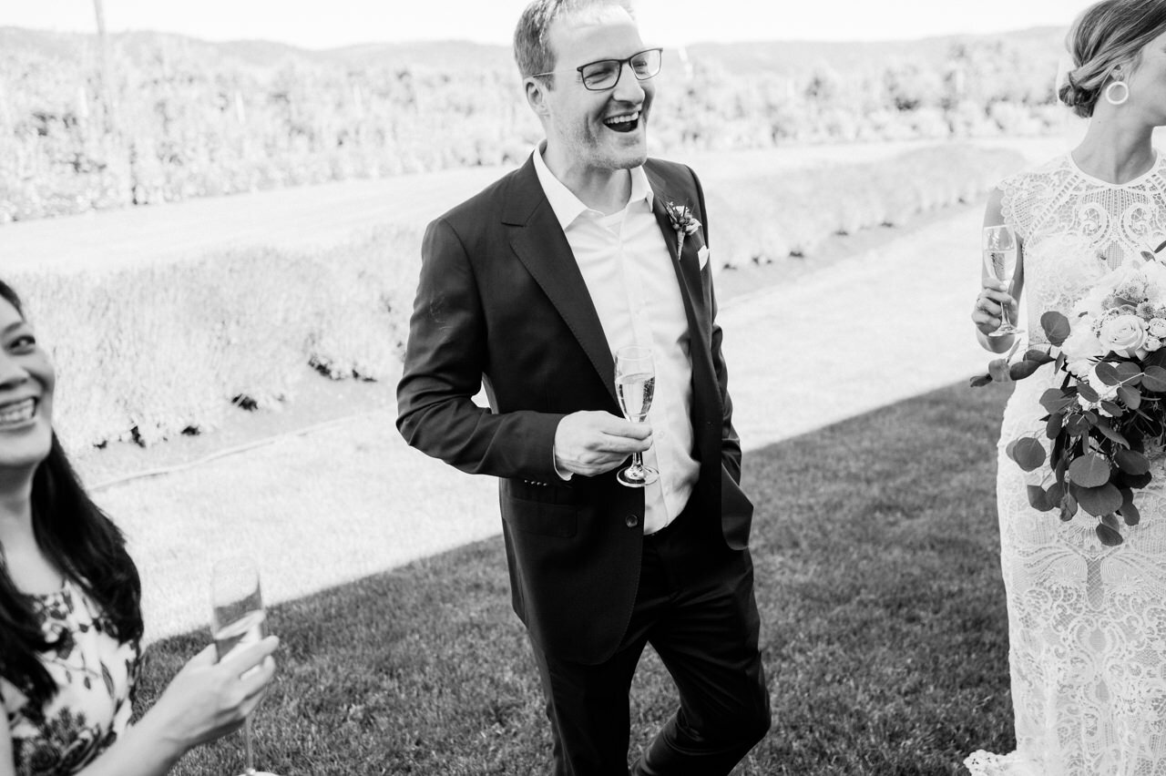  Groom laughs in black and white candid moment 